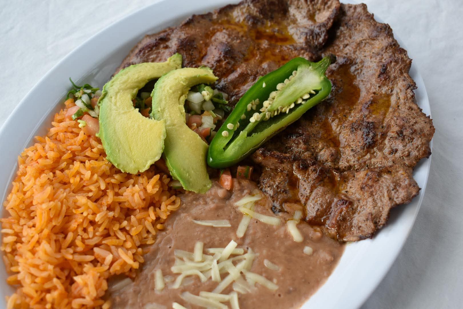 Carne Asada with rice, beans, avocado, pico de gallo, and grilled jalapeño